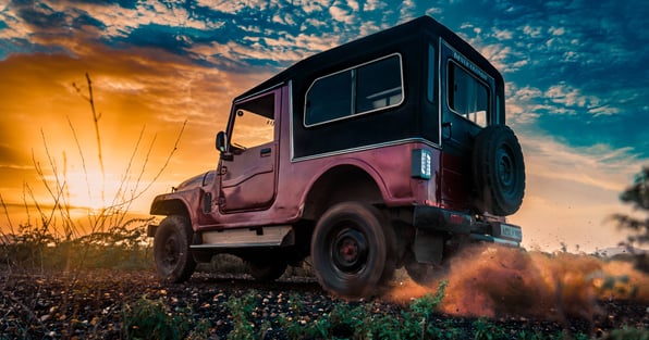 Jeep driving in the country at sunset