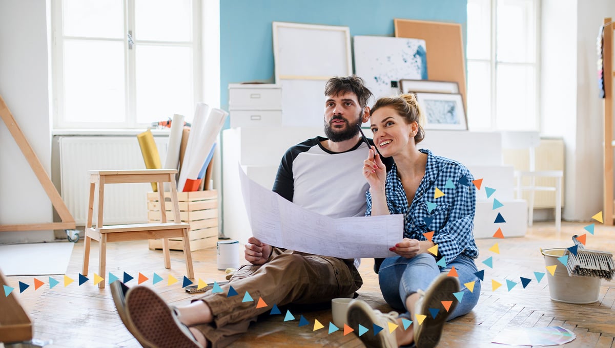 A couple sitting in the middle of a room during a home renovation. A couple sitting in the middle of a room during a home renovation.