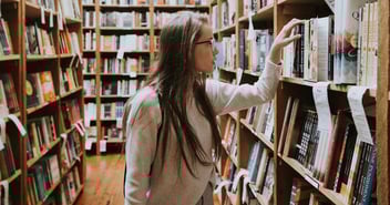 Woman looking at books in library