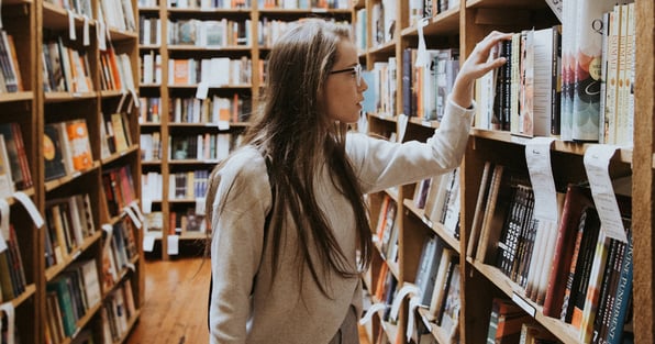 Woman looking at books in library