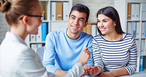 Husband and wife speaking to real estate agent