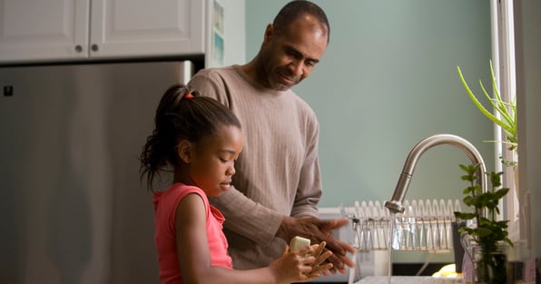 Father and daughter washing dishes together