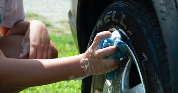 Someone cleaning tire of car