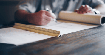 Someone writing on a sheet of paper