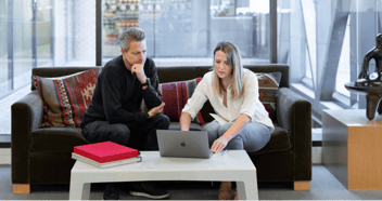 Two people sitting at laptop