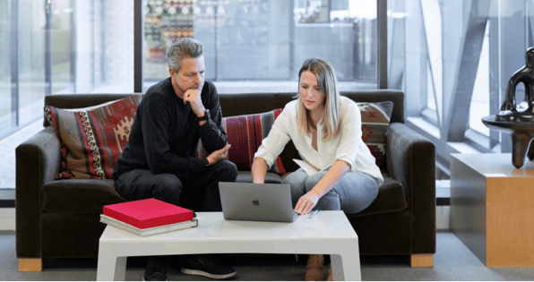 Two people sitting at laptop