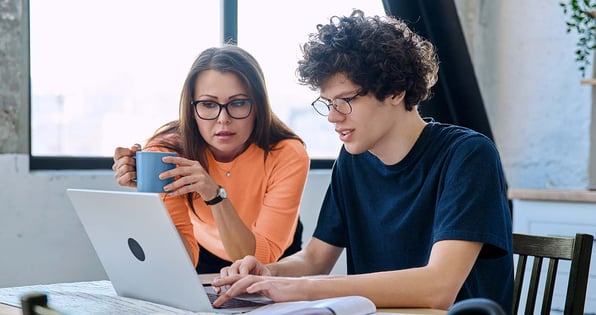 A mother and son looking at a computer screen