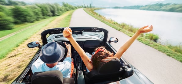 Two excited youngsters driving a car